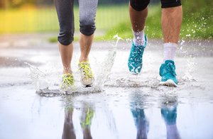 couple walking with wet running shoes in the rain